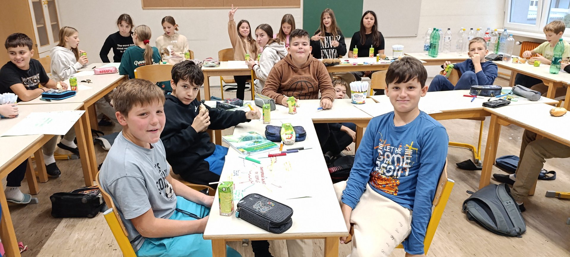 učenci pri mizi v razredu