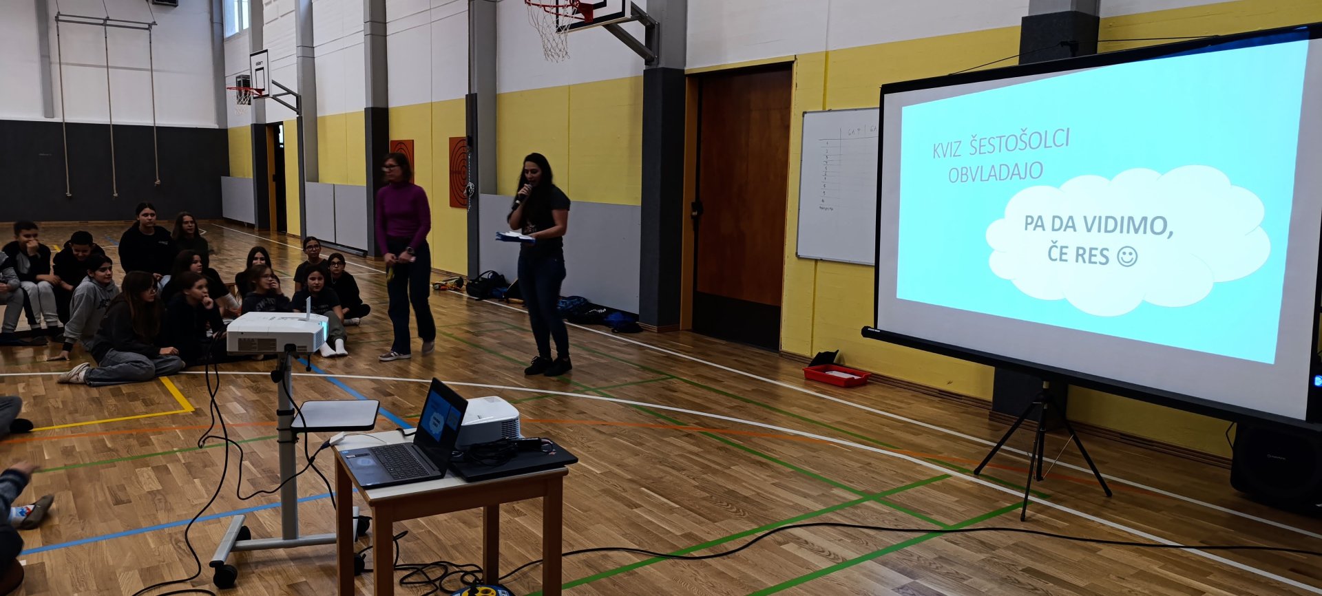 Učenci poslušajo predstavitev v šoli.